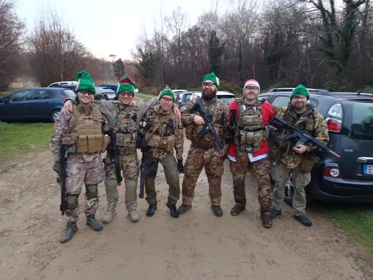 Sei giocatori softair in equipaggiamento con cappelli natalizi da elfo