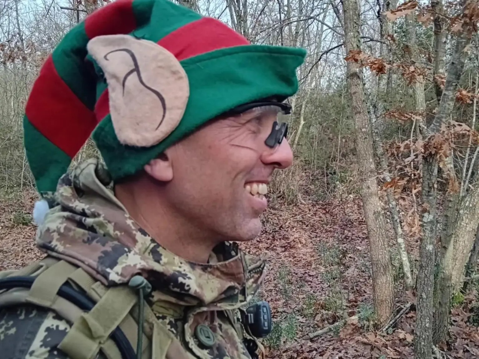 Giocatore softair sorridente con un cappello natalizio da elfo